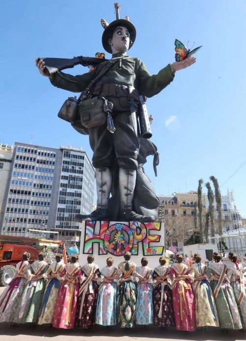 Falleras en traje tradicional ante el monumento de las Fallas de Valencia 2026, evento donde Cabisuar prestó servicio con su caseta modular