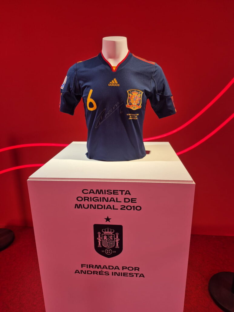 Camiseta original del Mundial 2010 firmada por Andrés Iniesta expuesta en el interior de las casetas modulares de la fan zone